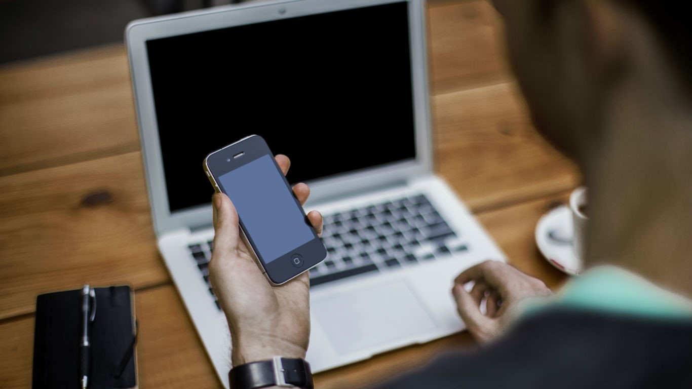 Person using their phone and laptop (Image: Shutterstock)